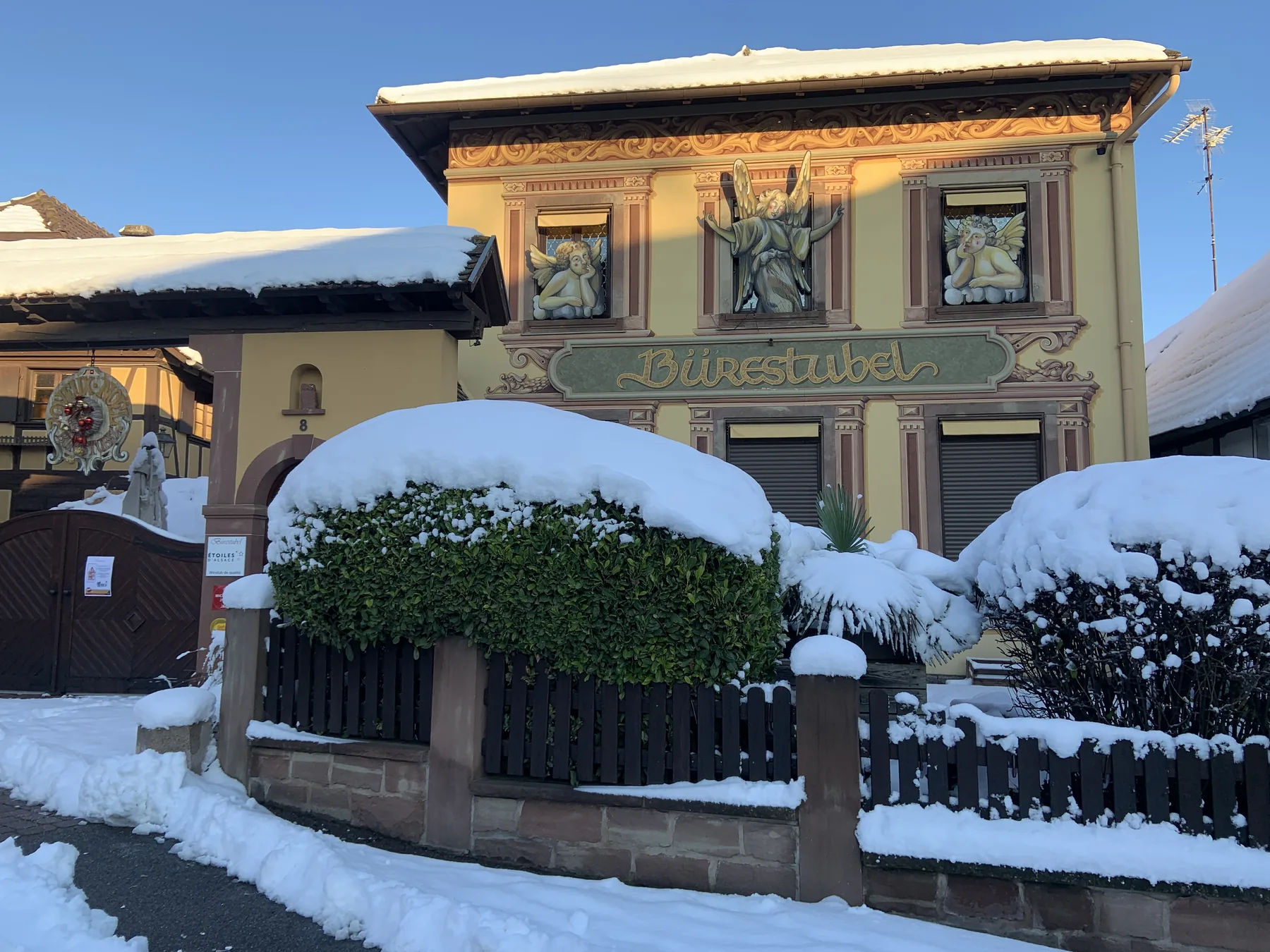La façade peinte du Bürestubel, winstub alsacienne, sous la neige