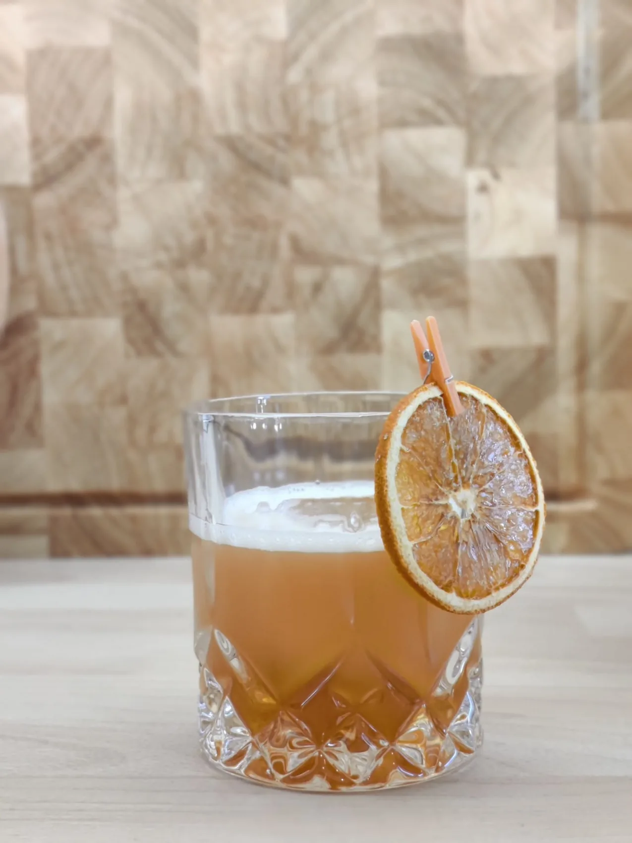 Un whisky sour garni d'une tranche d'orange séchée